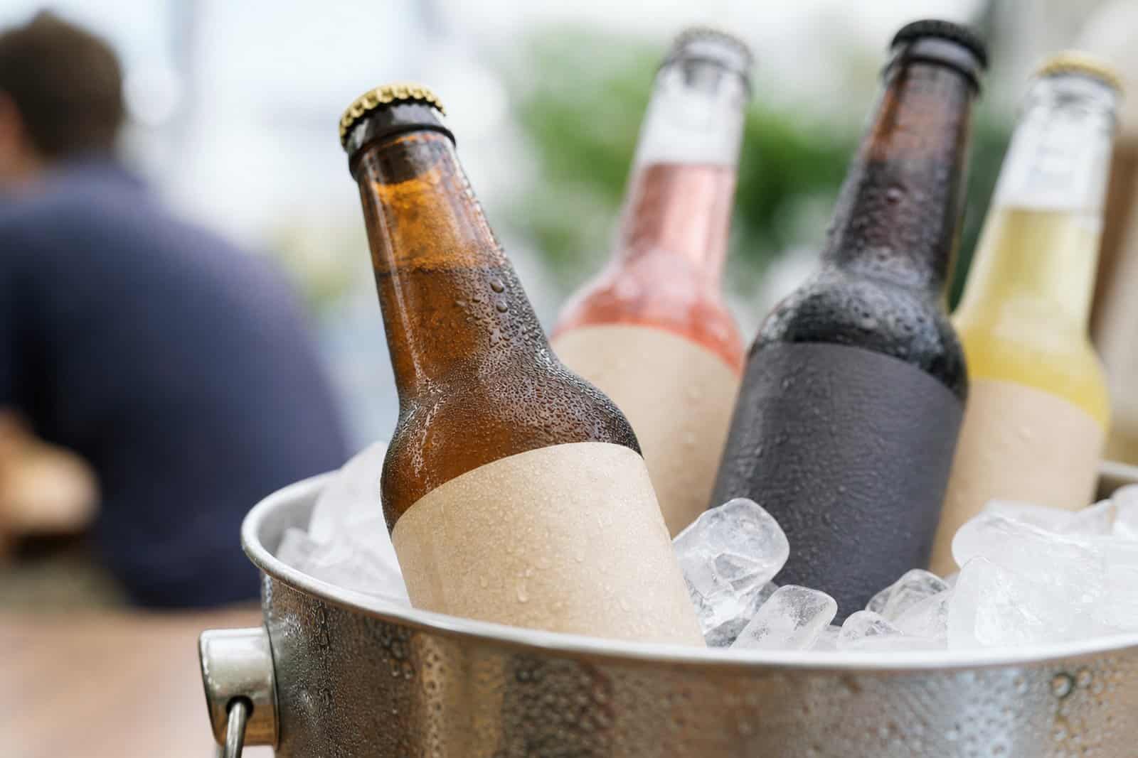 Craft beverage bottles with labels chilling in an ice bucket