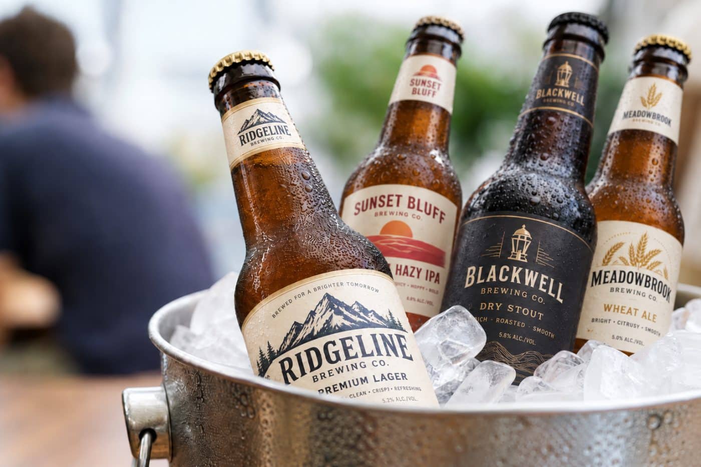 Craft beer cans and bottles in an ice bucket with labels intact under condensation